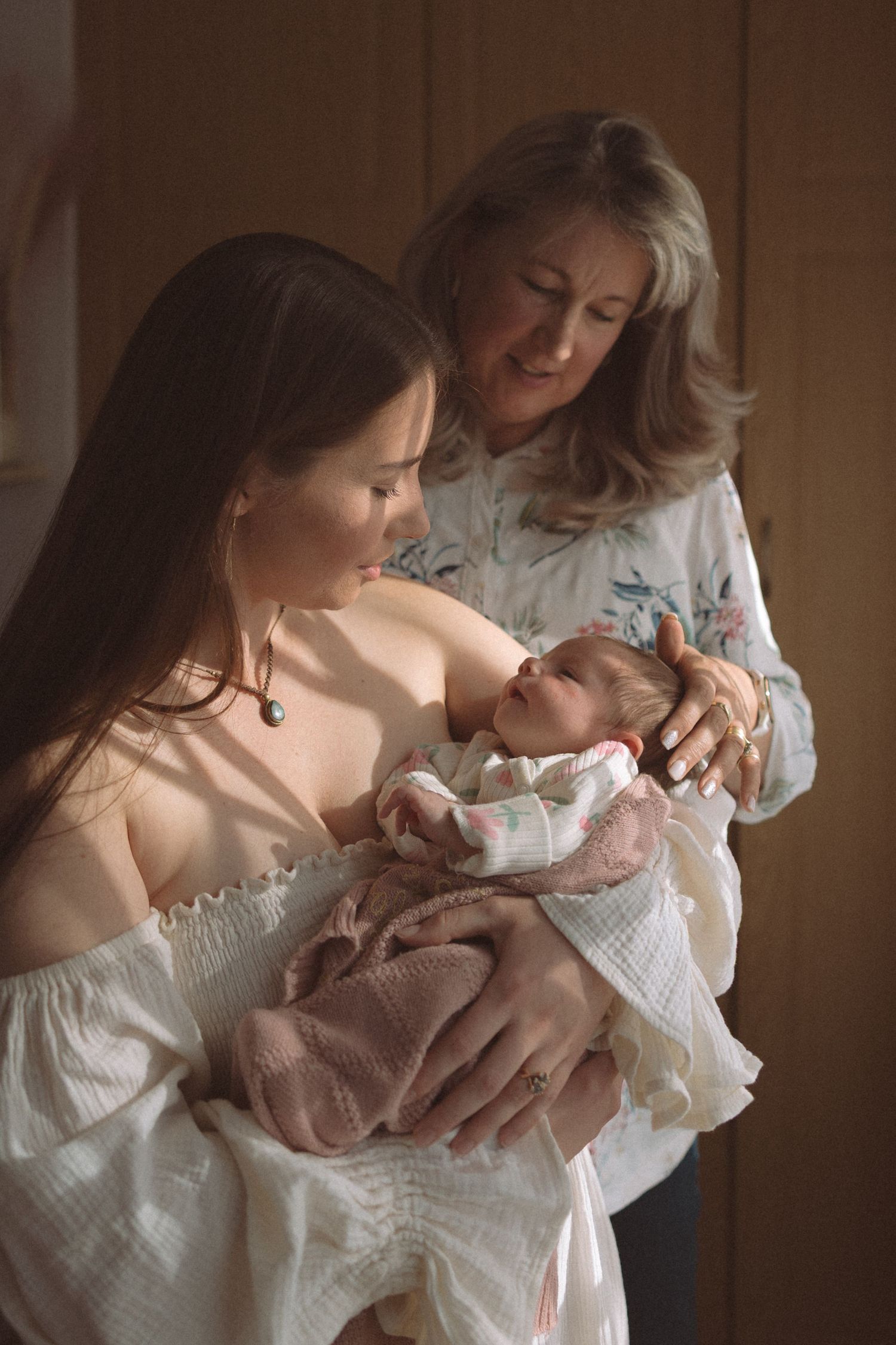 A series of tender moments captured between family members holding and bonding with a newborn baby in soft natural light.