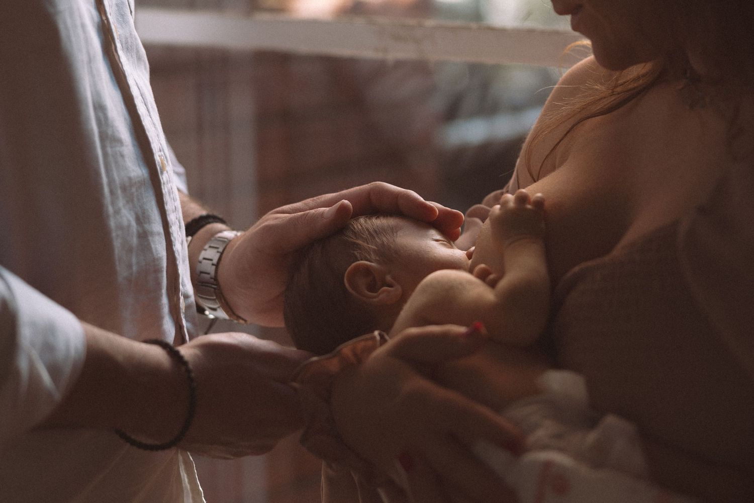 A newborn baby receives tender care during a precious bonding moment in warm, gentle lighting.
