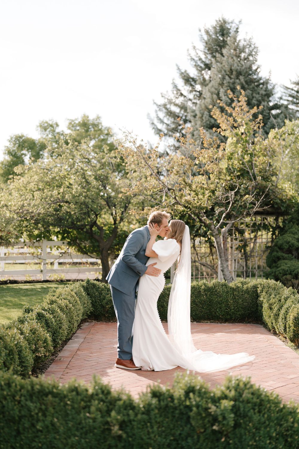 A romantic garden moment surrounded by manicured hedges and blooming trees.