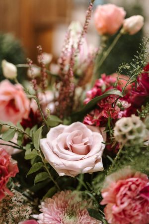 Close-up of pink and burgundy wedding flower arrangement featuring roses and mixed blooms.