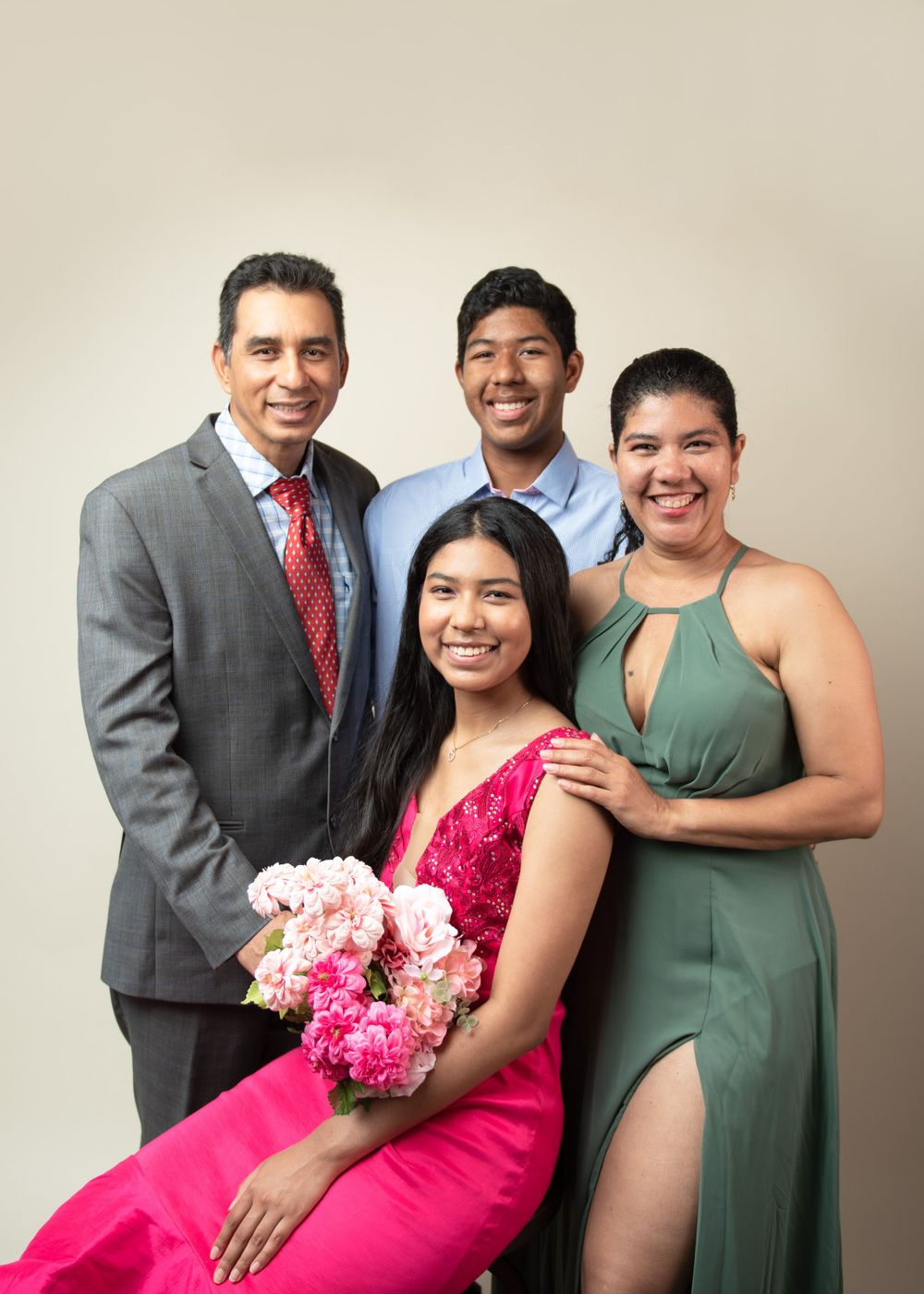Formal group portrait with pink flowers featuring elegant evening wear.