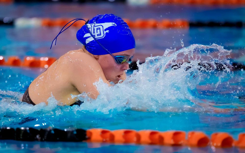 Lower Dauphin swimmer in blue cap racing breaststroke during Senior Night at Gettysburg pool.