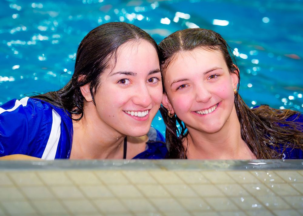 Lower Dauphin senior swimmers smiling together in the pool during Senior Night festivities.