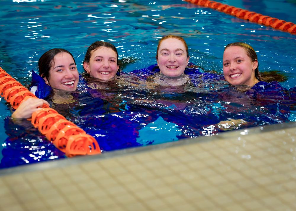 Group of Lower Dauphin swimmers smiling in the pool, celebrating Senior Night with friends and teammates.