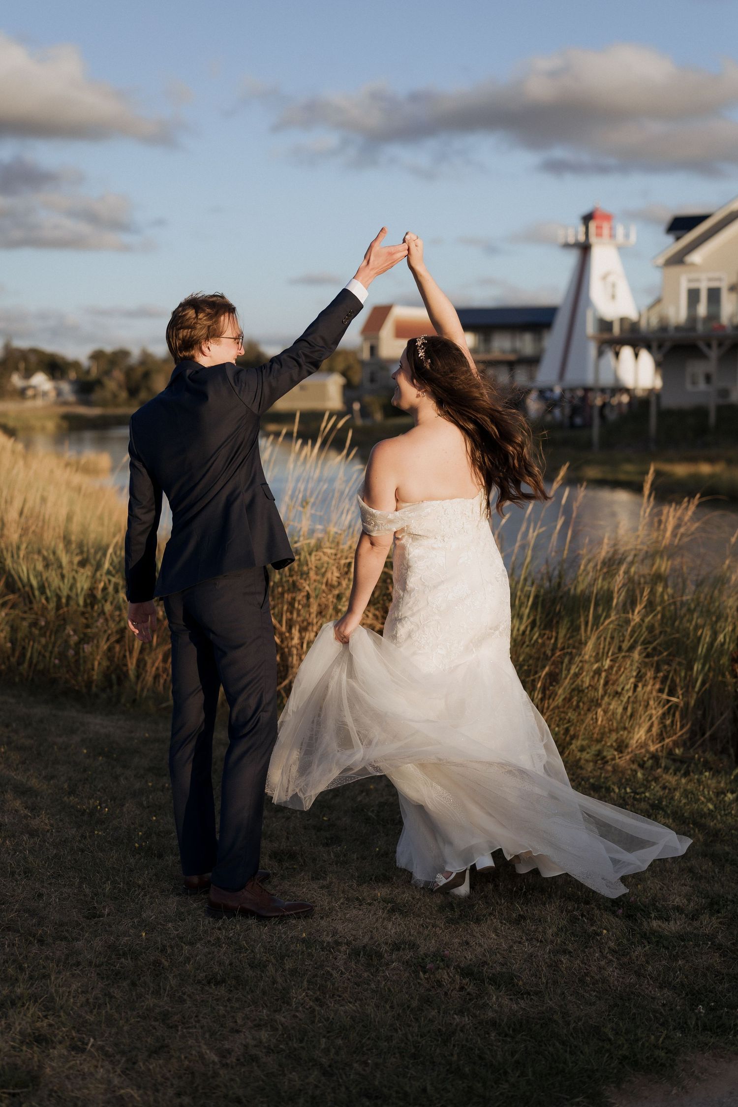 bride and groom dancing at sunset in front of a lighthouse  during golden hour at Parlee Beach, Shediac wedding photography New Brunswick