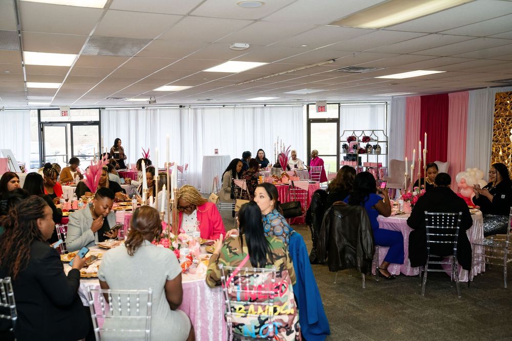 Large conference room filled with decorated tables and guests for a special celebration.