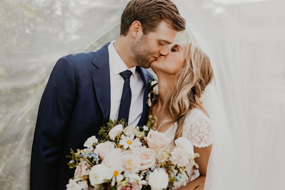 Romantic wedding portraits with white floral bouquet against soft natural lighting.