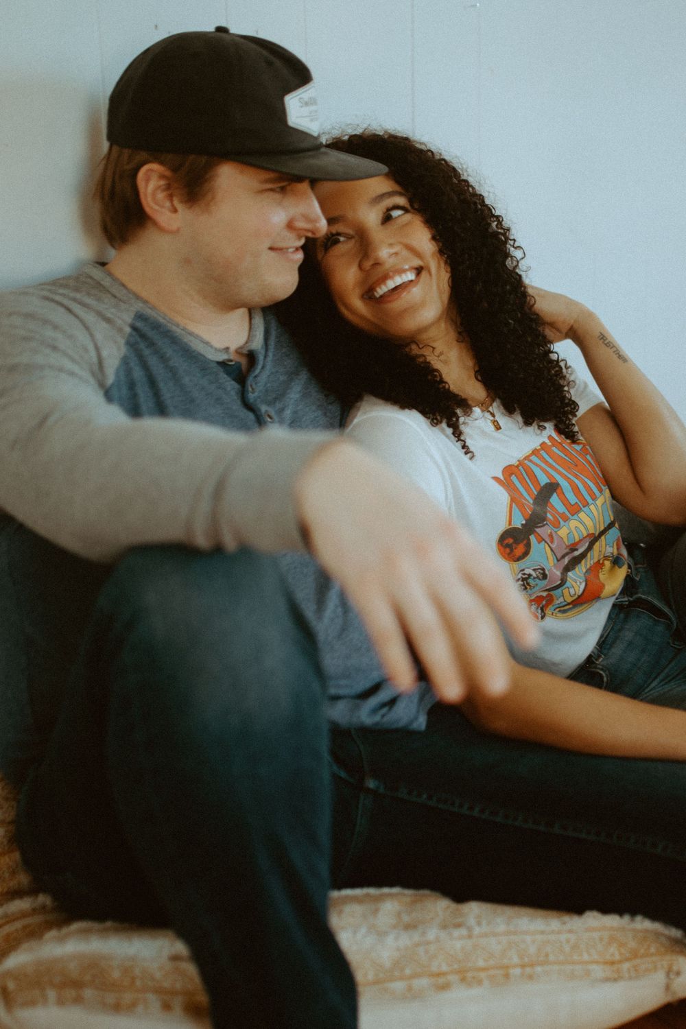 Candid couple lounging on couch sharing playful moments together.