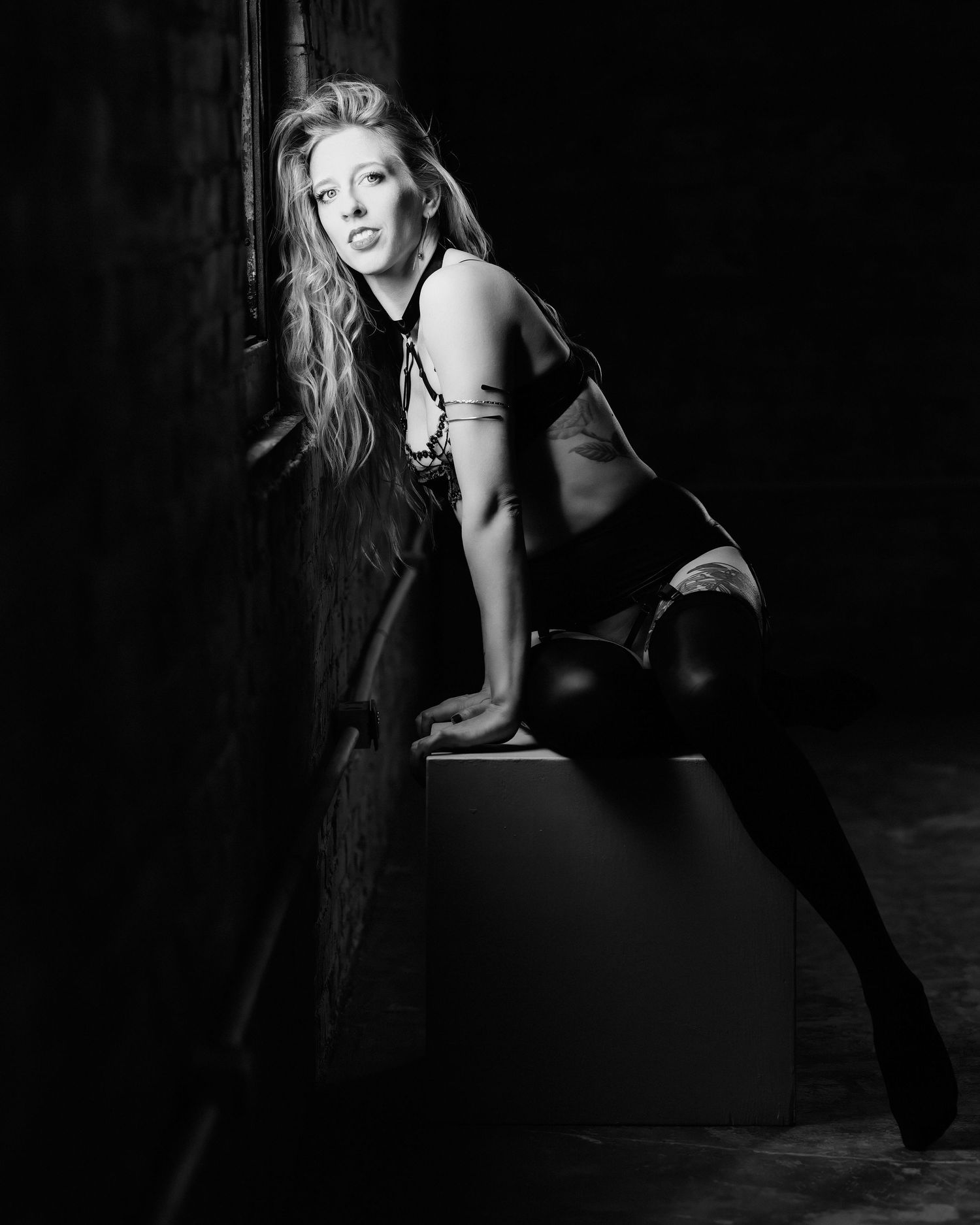 David G Holt Photography - Artistic black and white boudoir photo with dramatic lighting and long hair against dark background.
