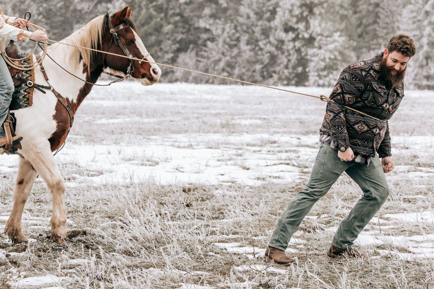 Cle Elum, WA engagement photography. Woman sitting on horse kissing tall man. A rope is wrapped around them.