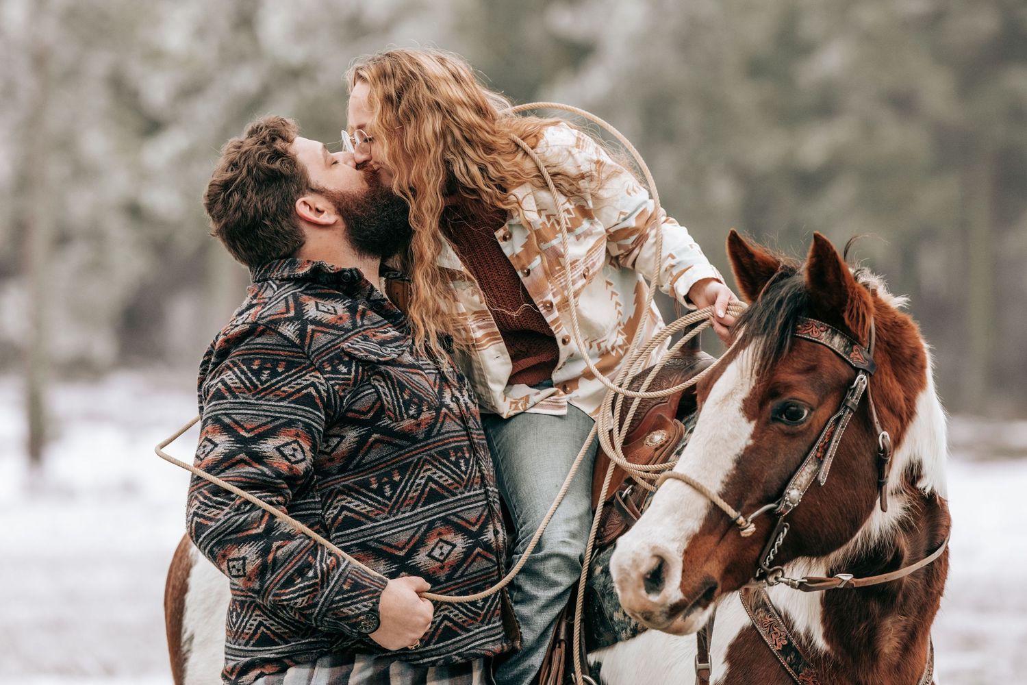 Cle Elum, WA engagement photography. Woman sitting on horse kissing tall man. A rope is wrapped around them.