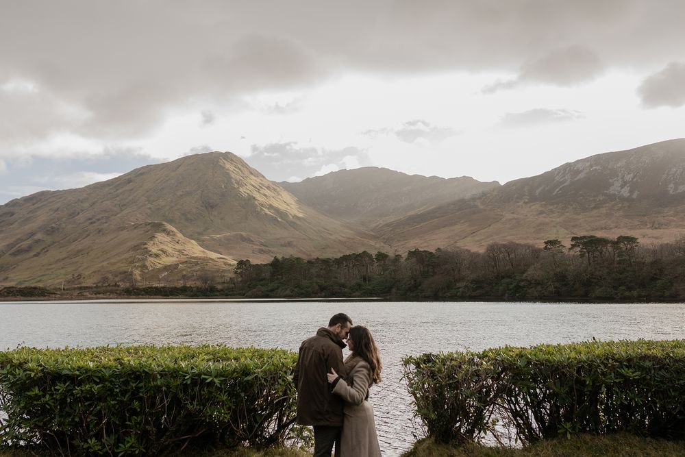 Couple holding hands along Pollacapall Lough path during winter adventure session