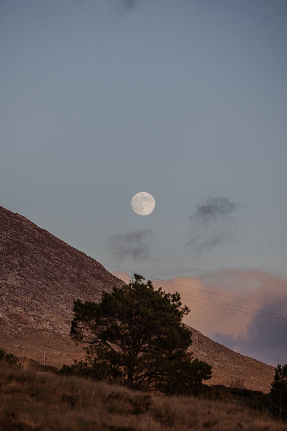 Dramatic winter sky with full moon during sunset in Connemara National Park