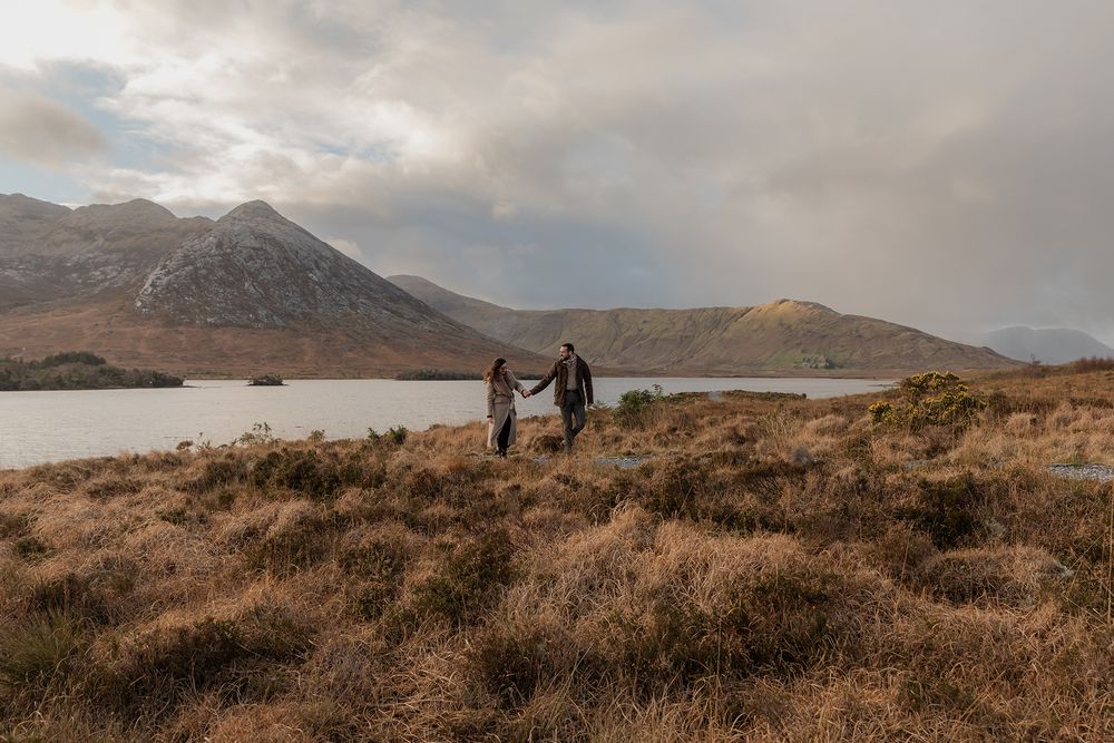 Couple walking along Connemara trail at sunset during adventure engagement session