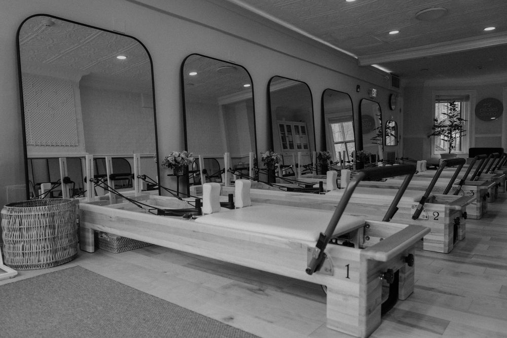 A series of black and white photographs showing the interior of a fitness center with various exercise equipment and machines.