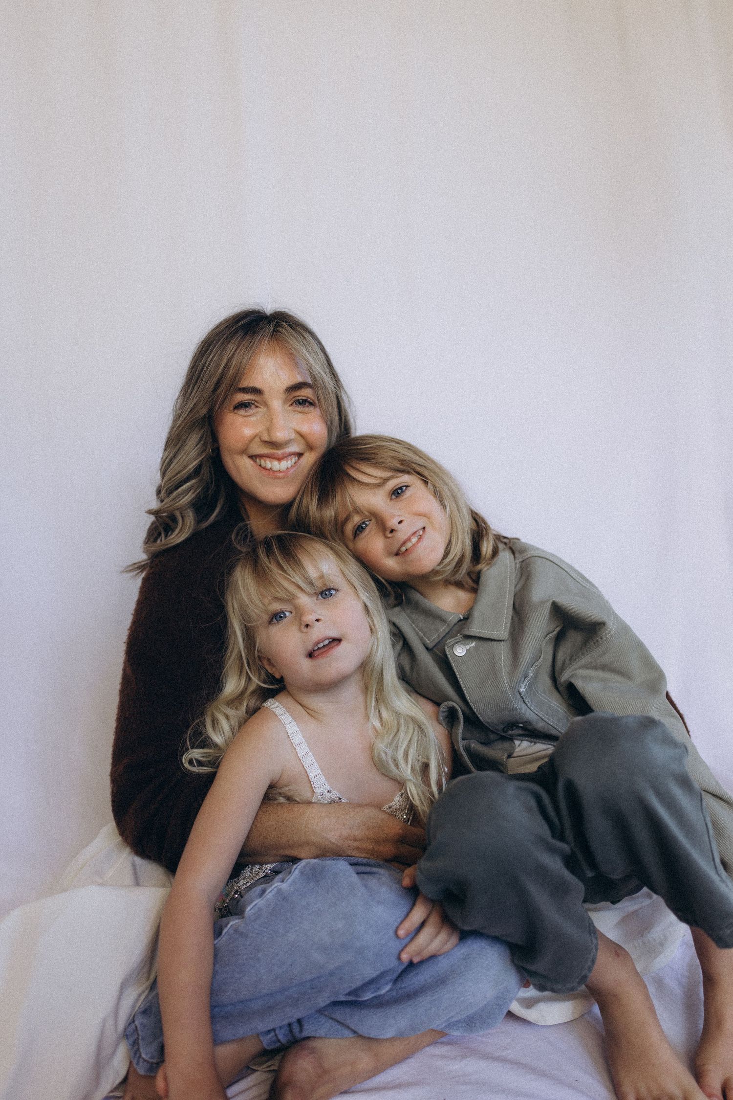 Mother smiling with two children during family studio session in Raglan, New Zealand