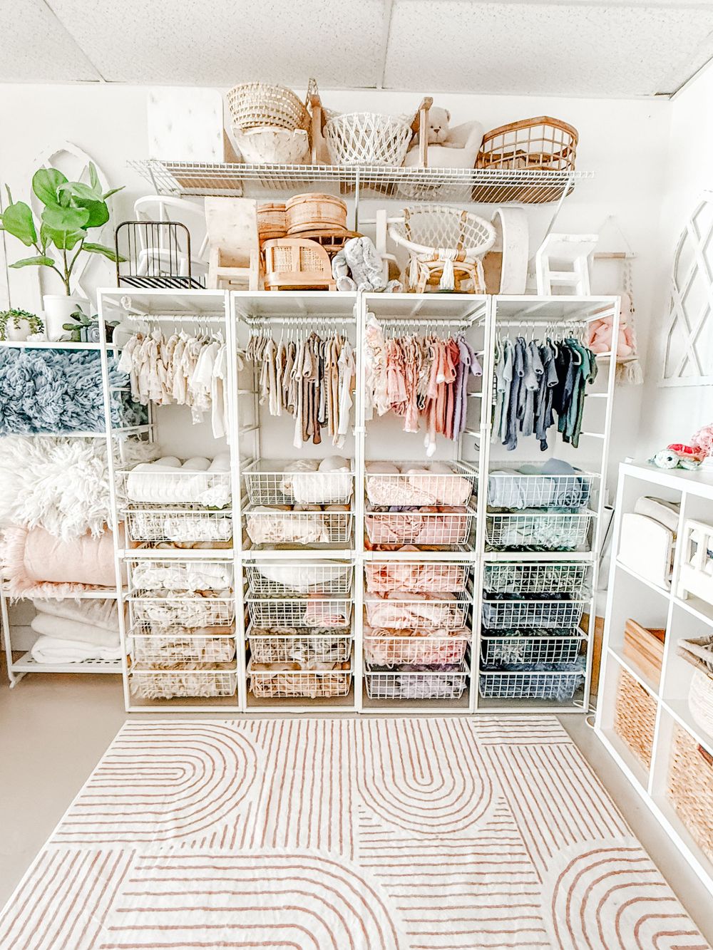 Modern laundry room with white cabinets, built-in shelving, and a decorative striped floor pattern in pink and white.