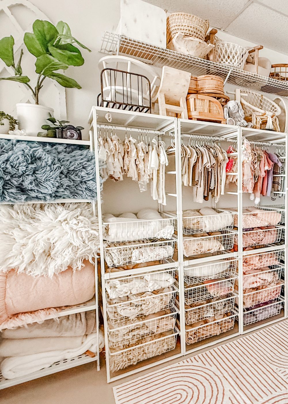 Organized closet storage system with white wire baskets and shelves displaying neatly folded linens and textiles.