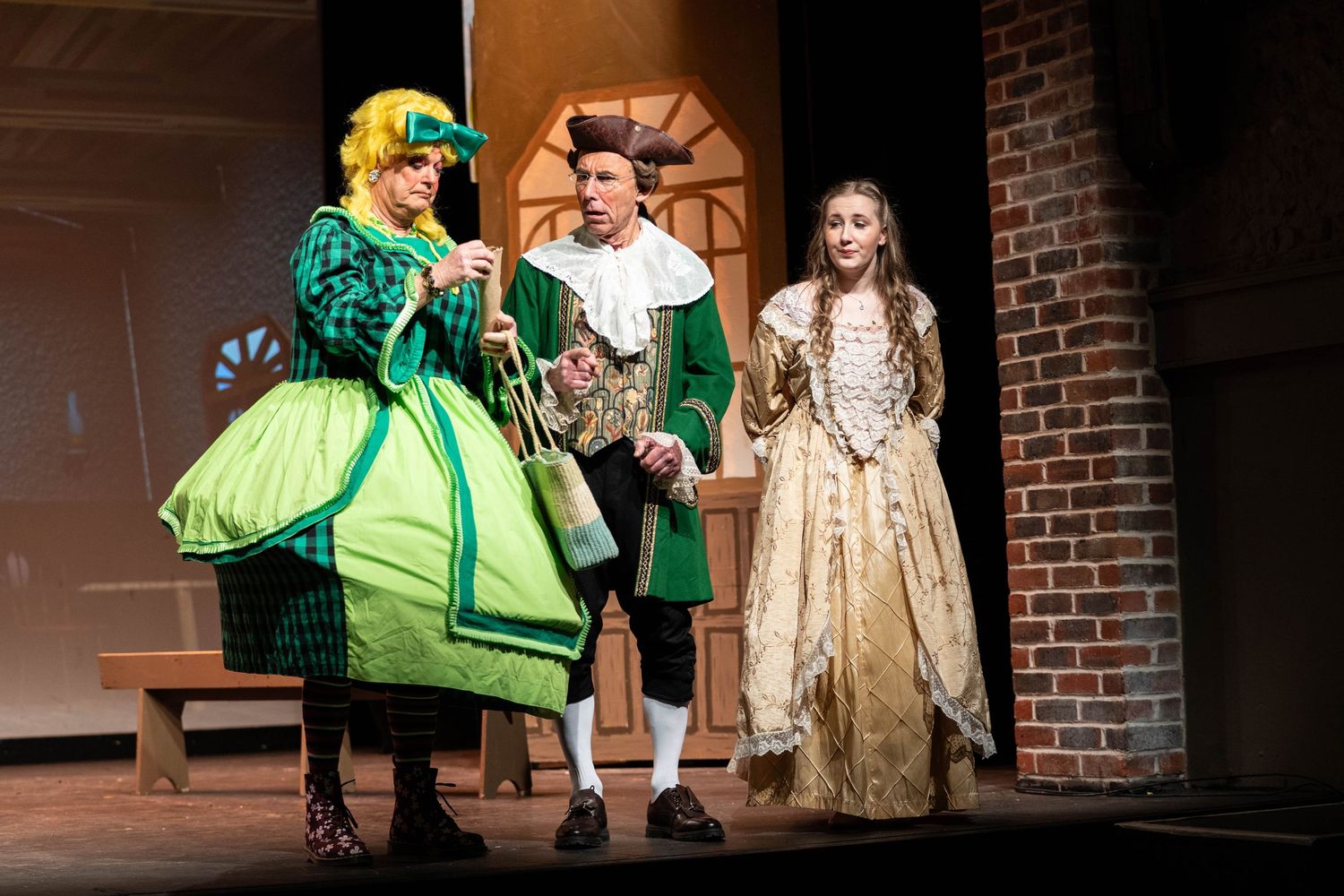Brighton theatre photography of 3 actors on stage in pantomime treasure island. the stage is lit form the back. a dame is on stage with capt