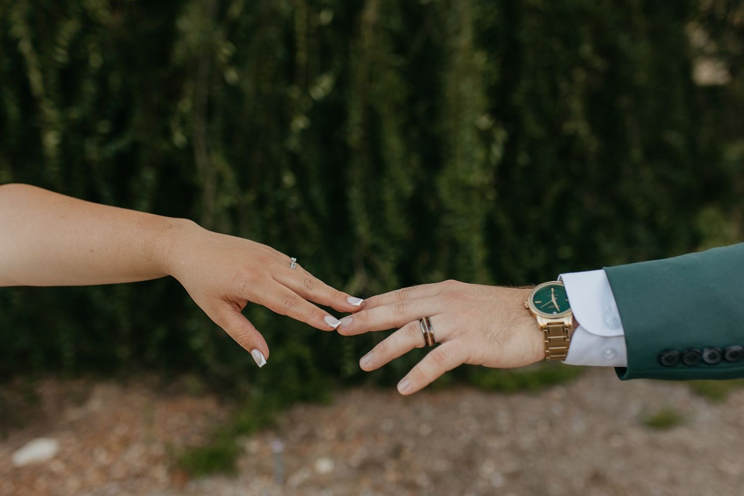 Close-up view of a bride and groom reaching for each other at Canopy Grove by Wedgewood Weddings.