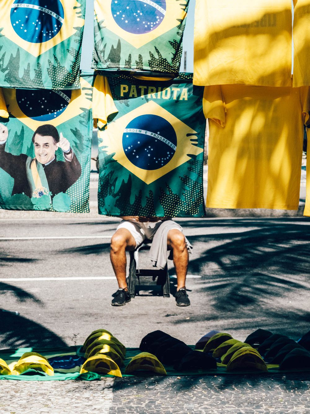 Athlete performing burpee exercises on pavement with Brazilian flag mural in background during workout sequence.