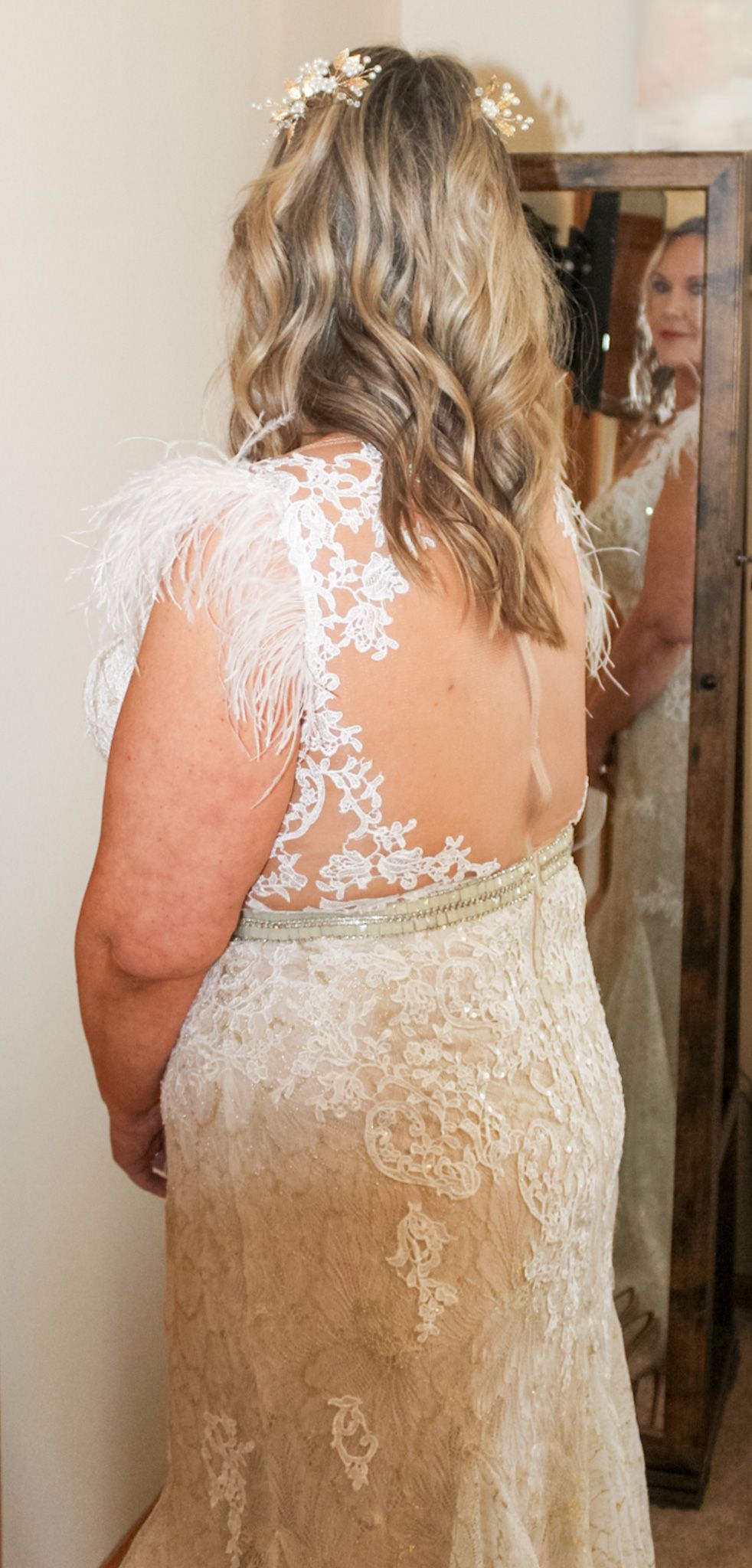 Detailed back view of an ivory lace wedding dress with intricate floral patterns and delicate sheer details.