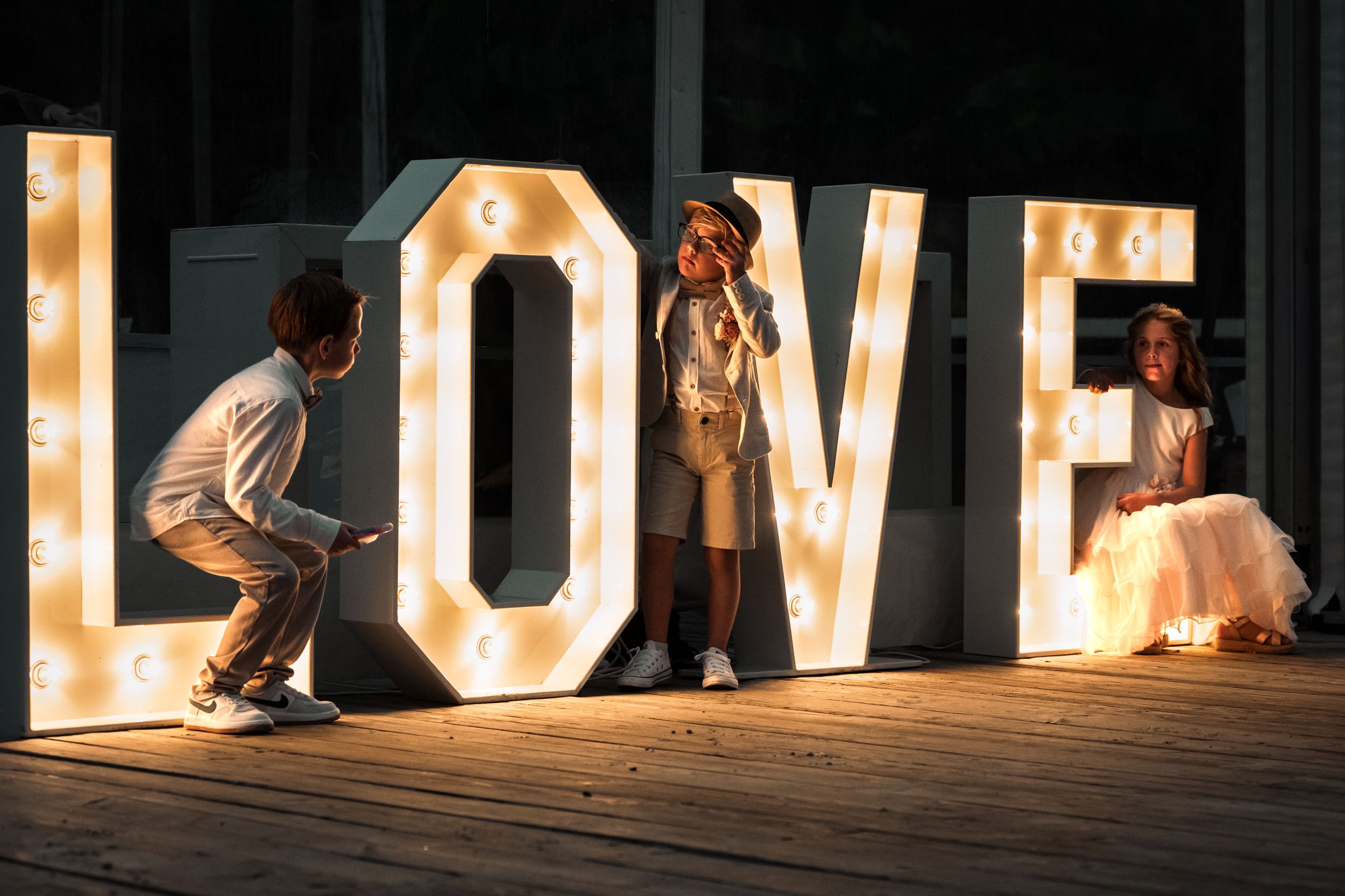 Illuminated marquee letters spelling LOVE glow warmly against a dark background creating a romantic atmosphere.