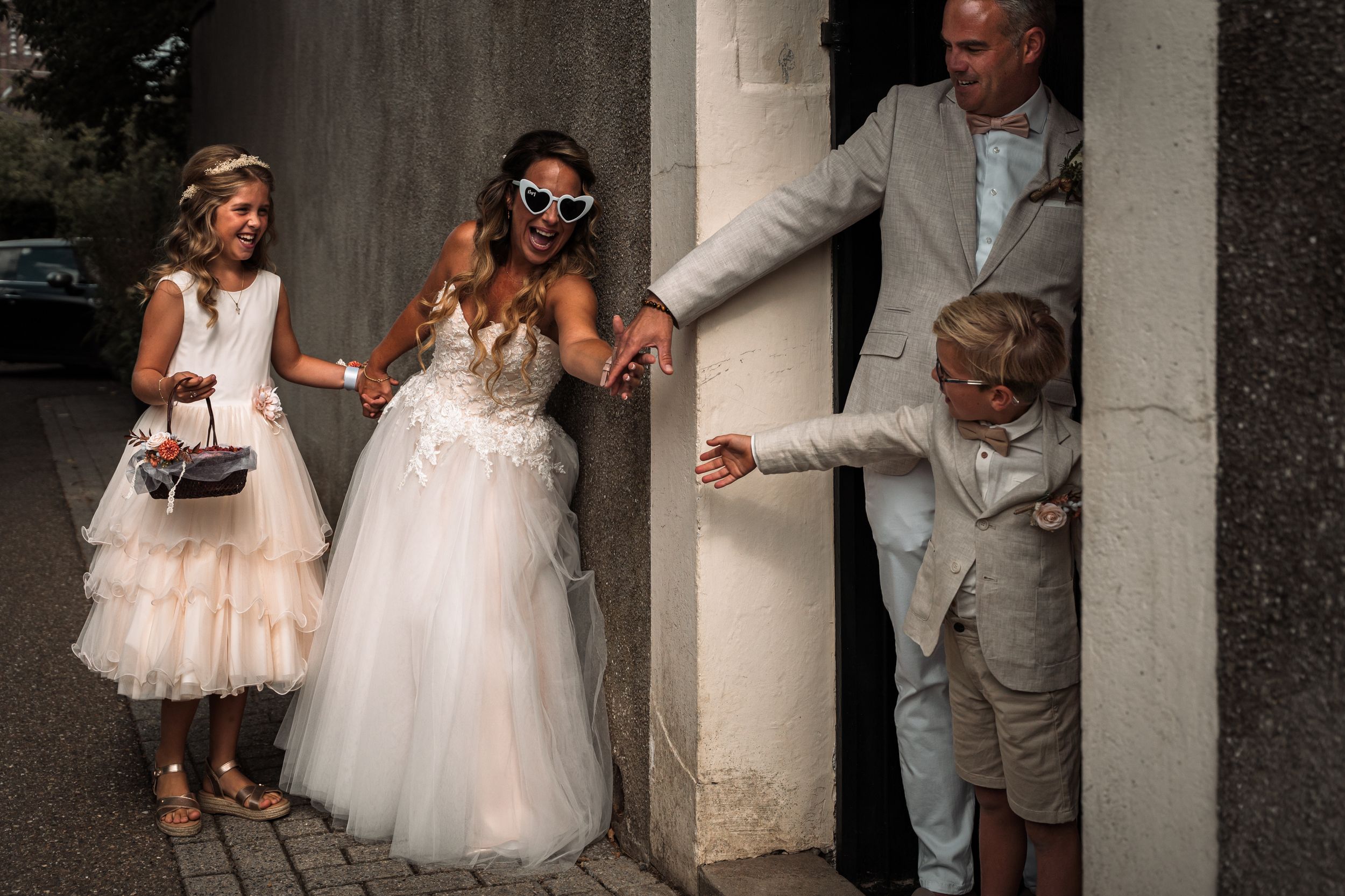 A series of wedding photos showing candid moments between a couple and bridesmaids in white dresses near stone columns.