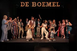 Performers on stage during a theatrical production with dramatic lighting and expressive movements.