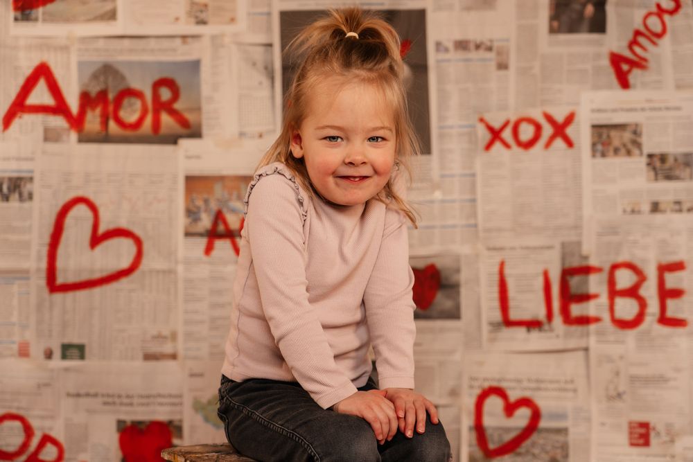 Creative love themed photoshoot with a young girl, using a handmade backdrop.