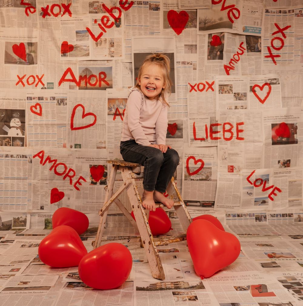 Creative love themed photoshoot with a young girl, using a handmade backdrop.