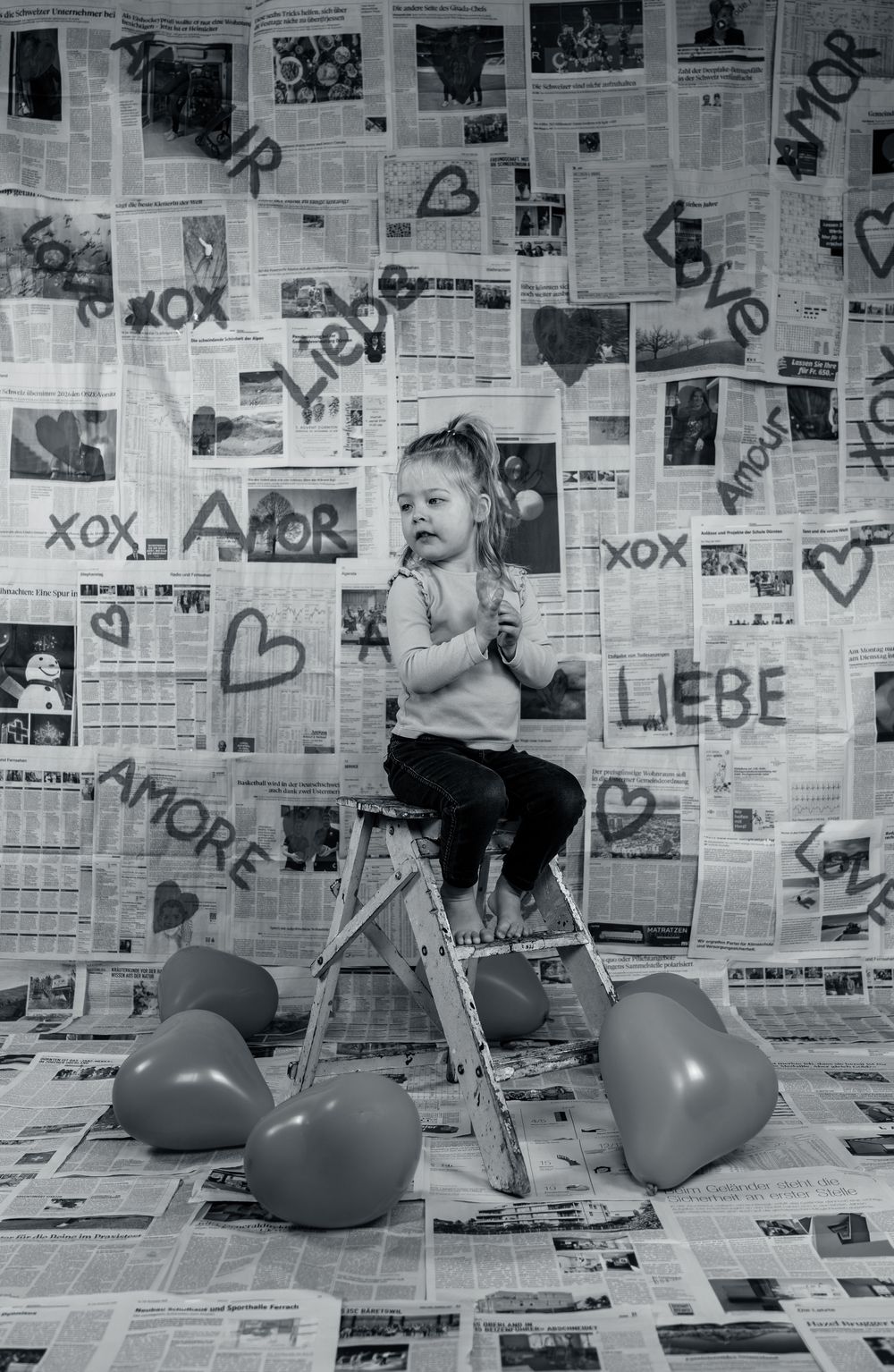 Creative love themed photoshoot with a young girl, using a handmade backdrop.