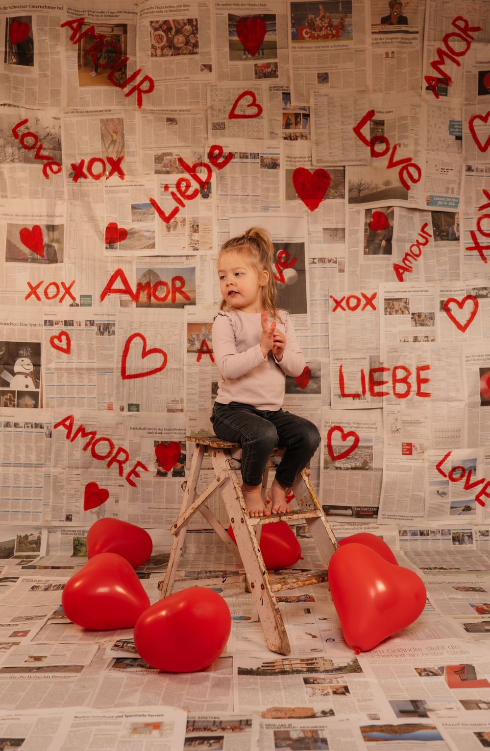 Creative love themed photoshoot with a young girl, using a handmade backdrop.