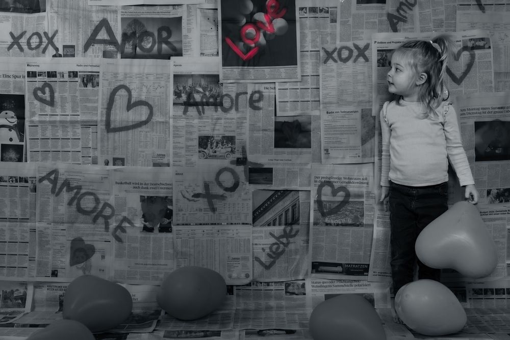 Creative love themed photoshoot with a young girl, using a handmade backdrop.