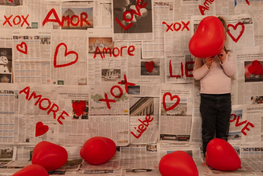 Creative love themed photoshoot with a young girl, using a handmade backdrop.