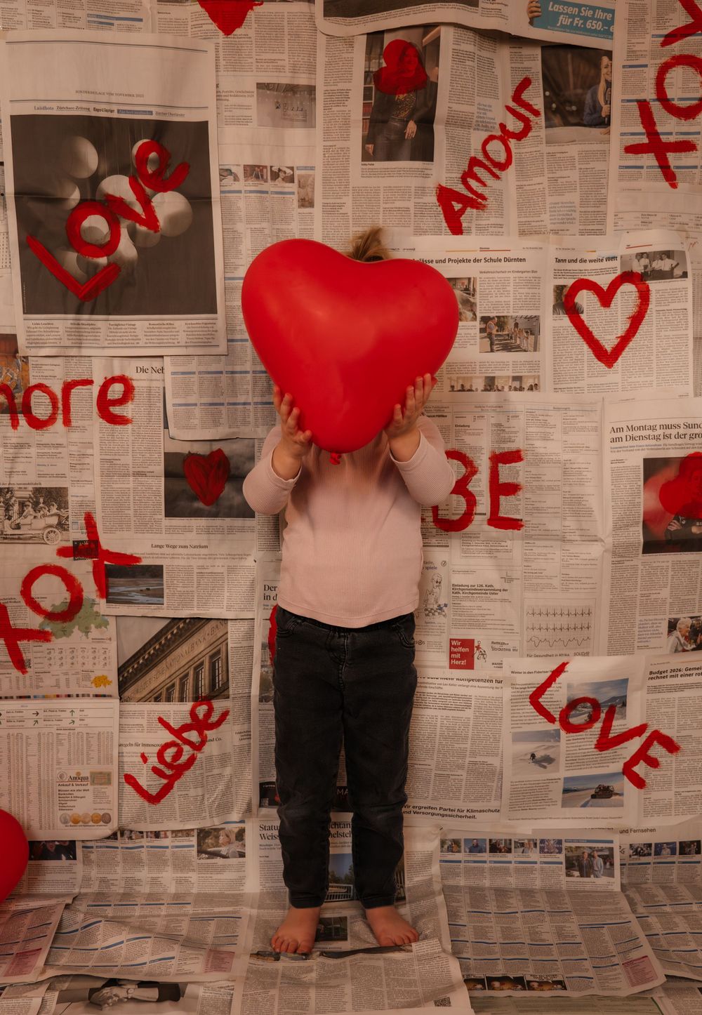 Creative love themed photoshoot with a young girl, using a handmade backdrop.