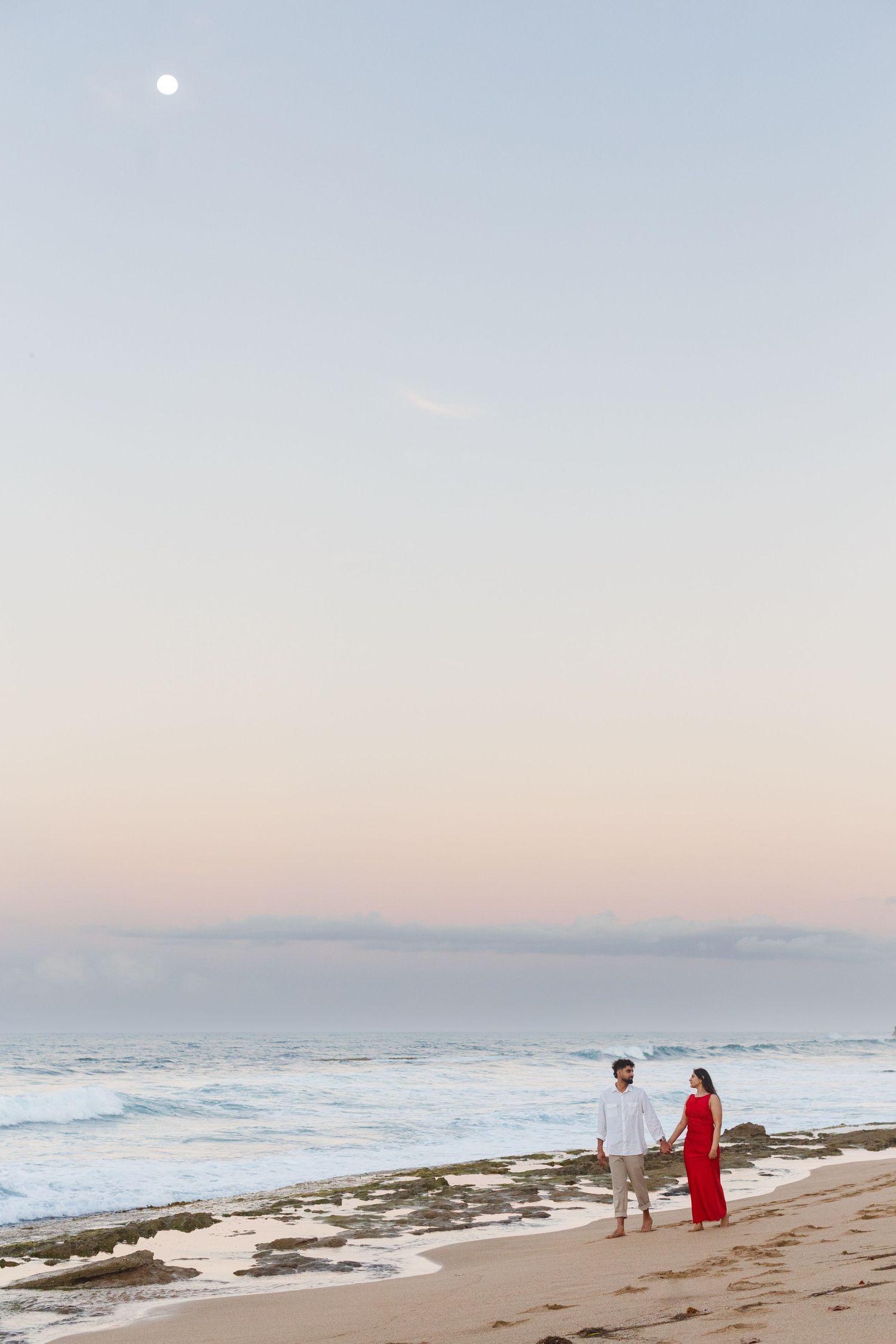 Couples portrait. Proposal and engagement session. Man and woman on the beach. Full moon in the sky. Kikita Surf Beach, Dorado, Puerto Rico.