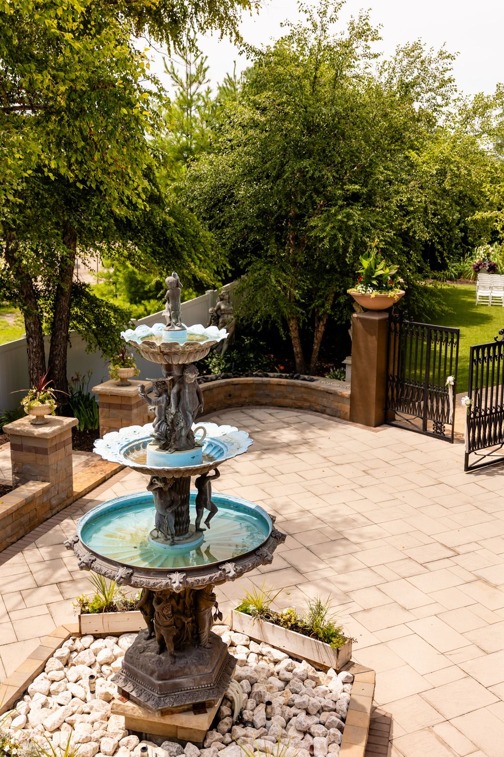 Decorative stone fountain with water feature in landscaped garden patio area at Villa Aletta in Omaha, NE.