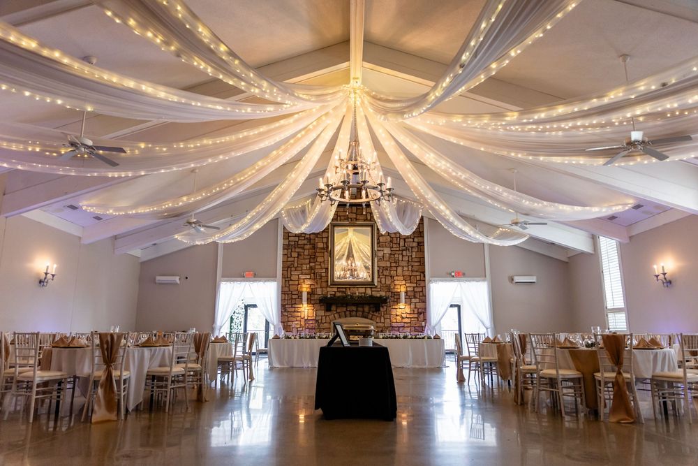 Elegant reception hall with draped fabric ceiling and twinkling lights creating a romantic atmosphere at Villa Aletta in Omaha, NE.