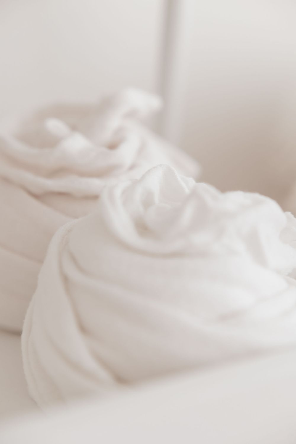 Delicate white fabric folds creating soft, dreamy texture in natural light.