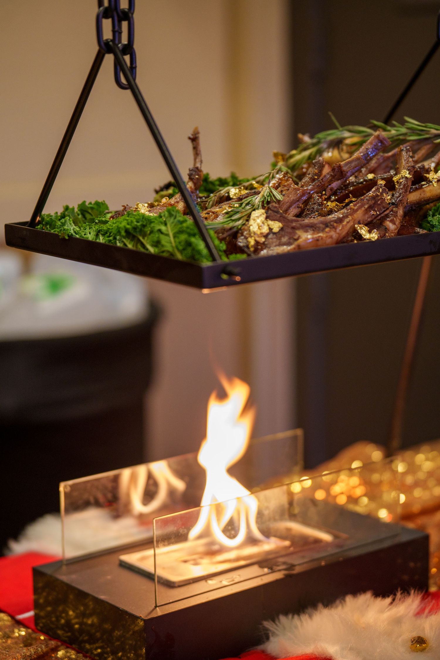 Elevated food platter suspended above a modern tabletop fire display showcasing gourmet appetizers and flames.