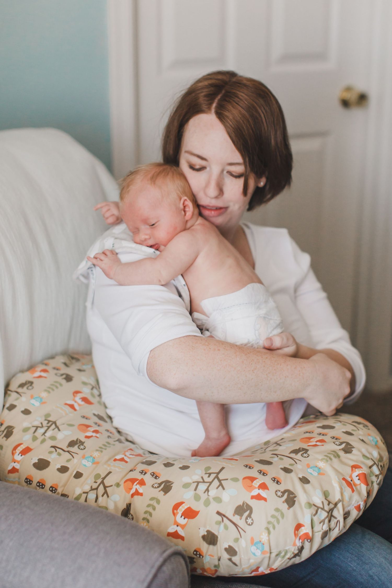 Parent and baby share intimate bonding moments on a floral nursing pillow.