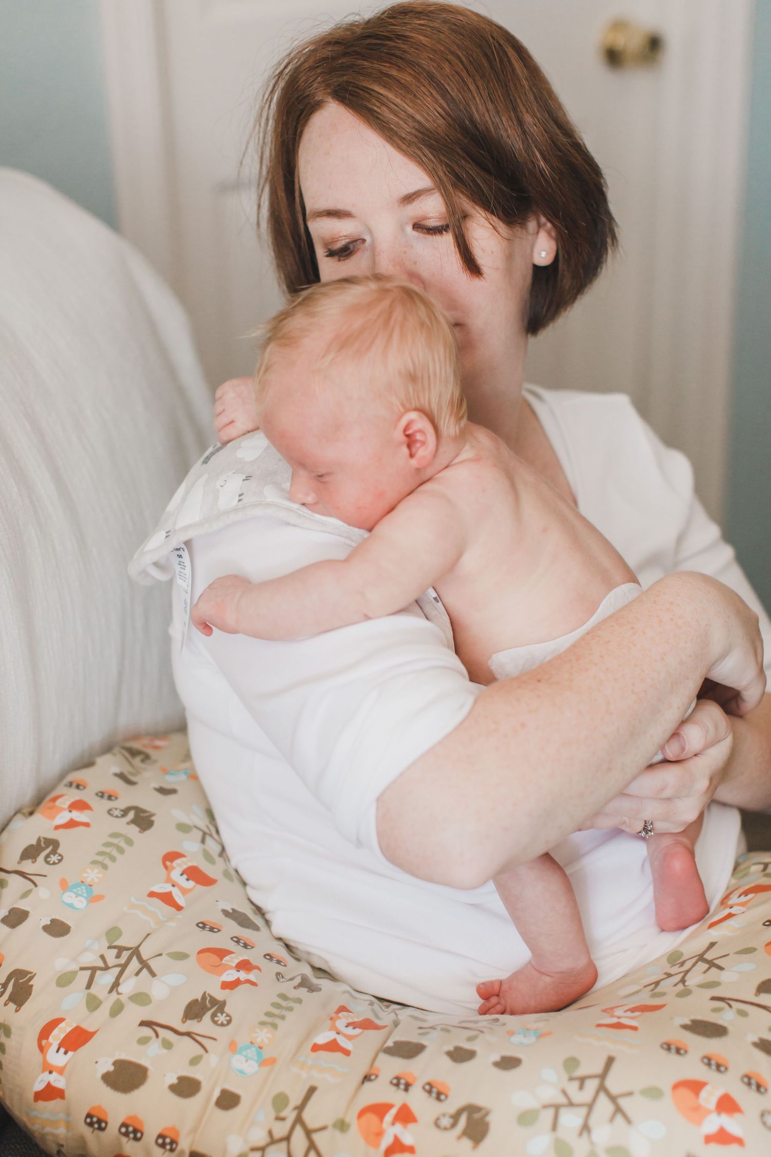 Tender moments between parent and baby while resting on a floral nursing pillow.
