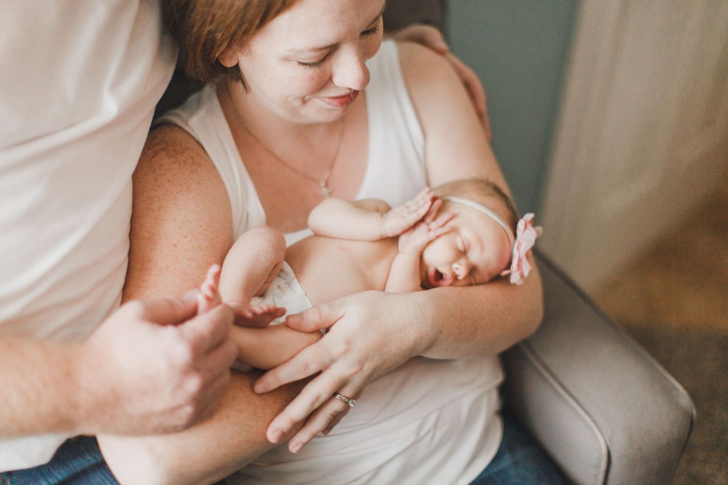 Intimate moment showing gentle hands cradling a sleeping newborn.