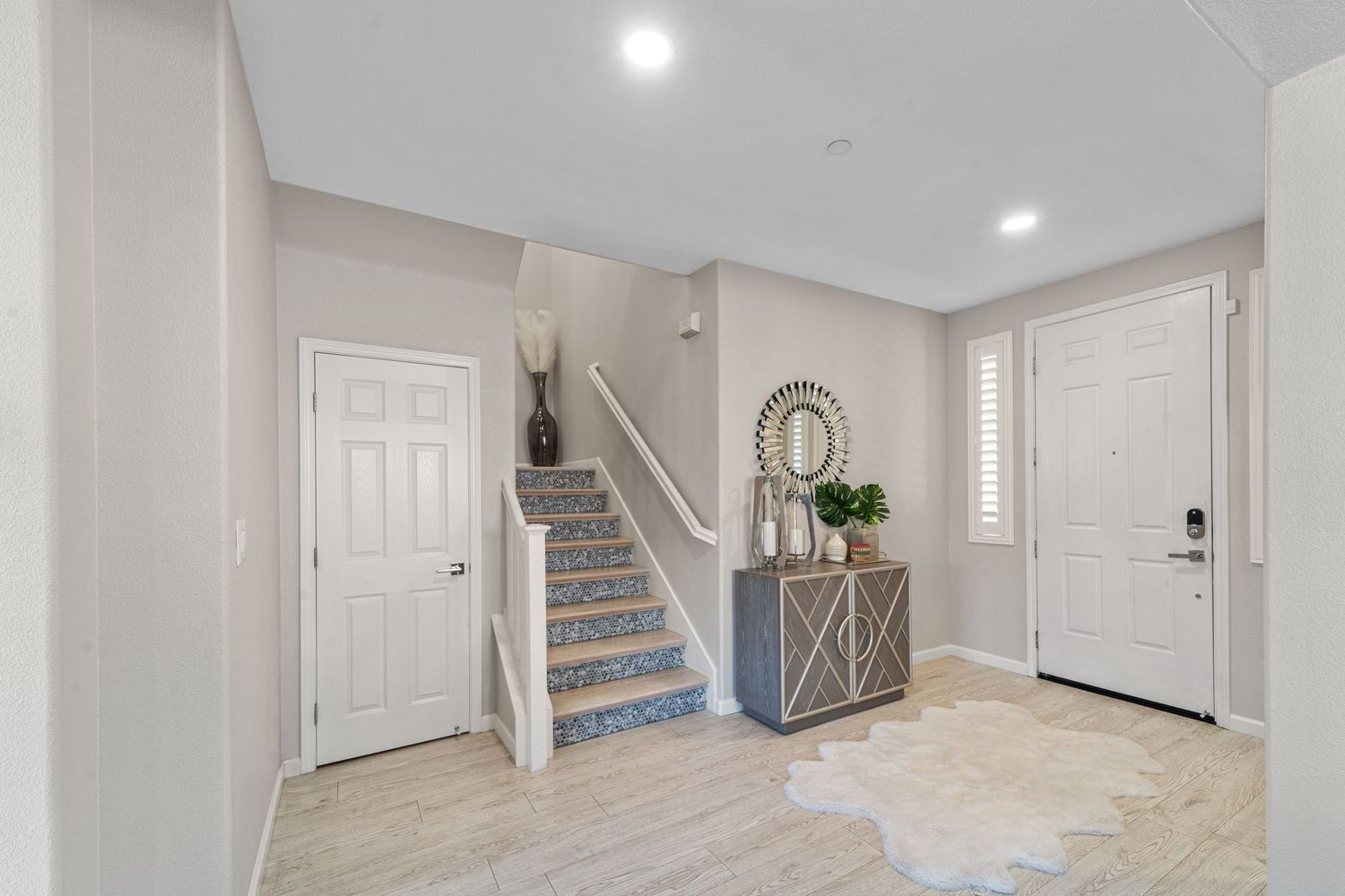 Bright basement corridor with white walls, carpeted stairs, and modern lighting fixtures illuminating the space.
