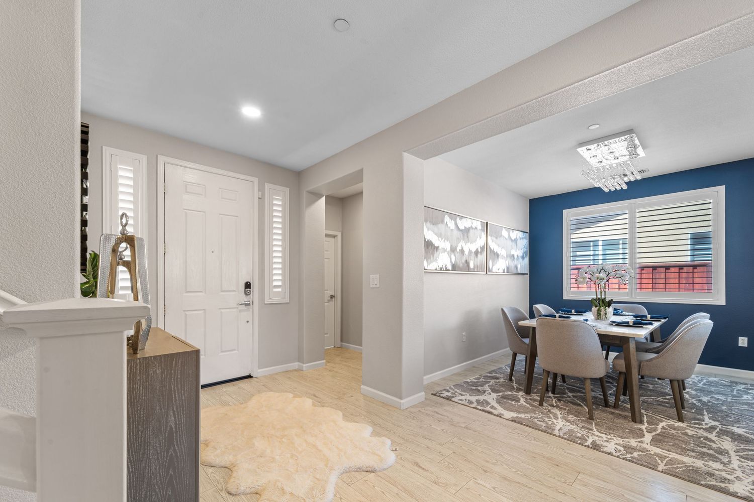 Panoramic view of an open concept living area with white walls and modern furnishings.