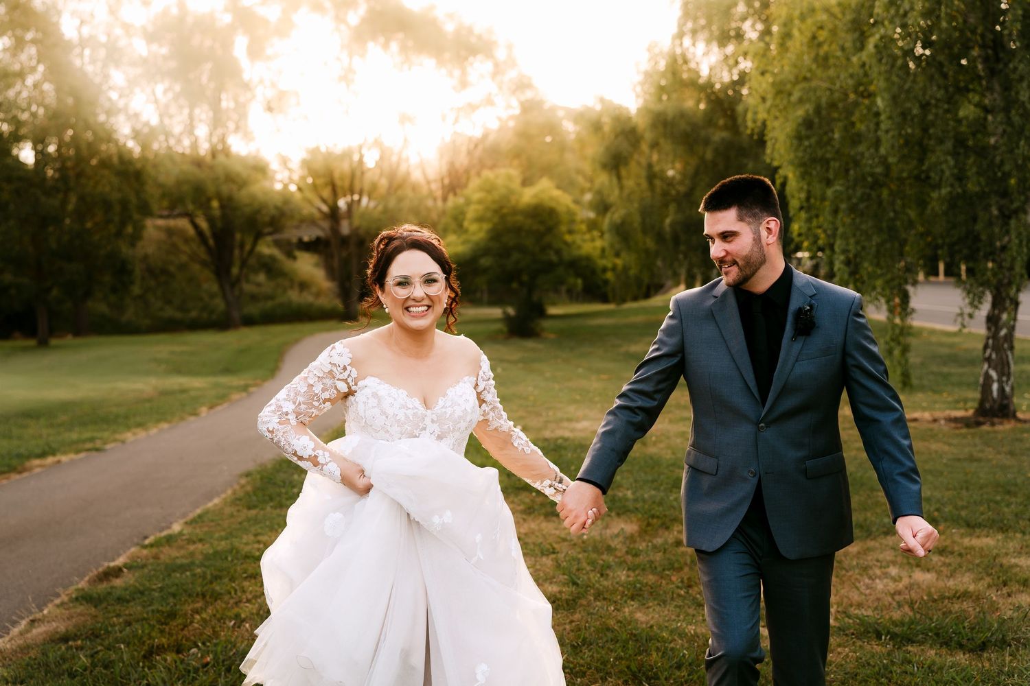 A coastal wedding photoshoot with a couple on a rocky beach against blue skies and ocean waves.