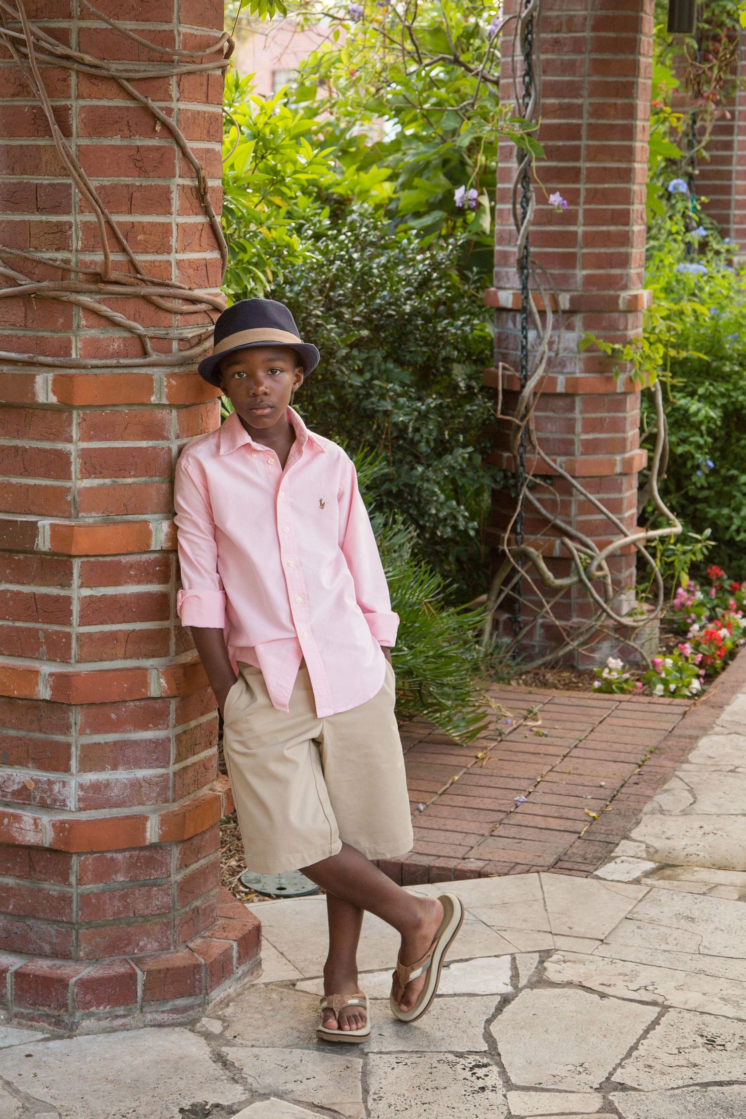 Four expressive portraits of a young person in a blue shirt and gray hat posing against a light background.