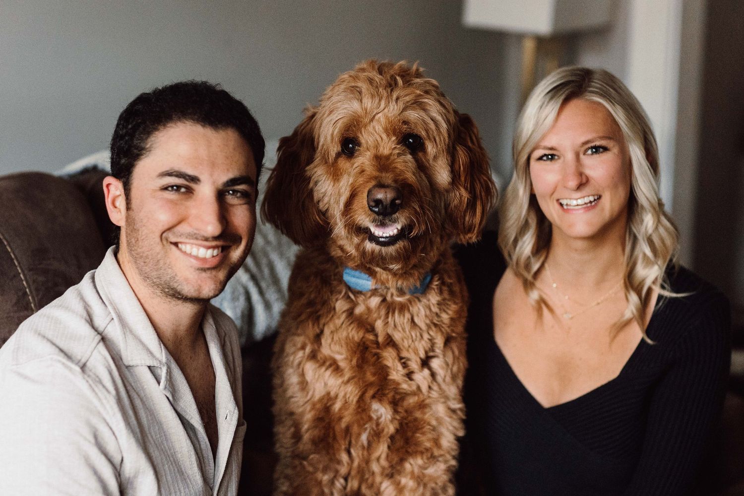 A couple poses with their golden retriever dog for a series of casual portraits.