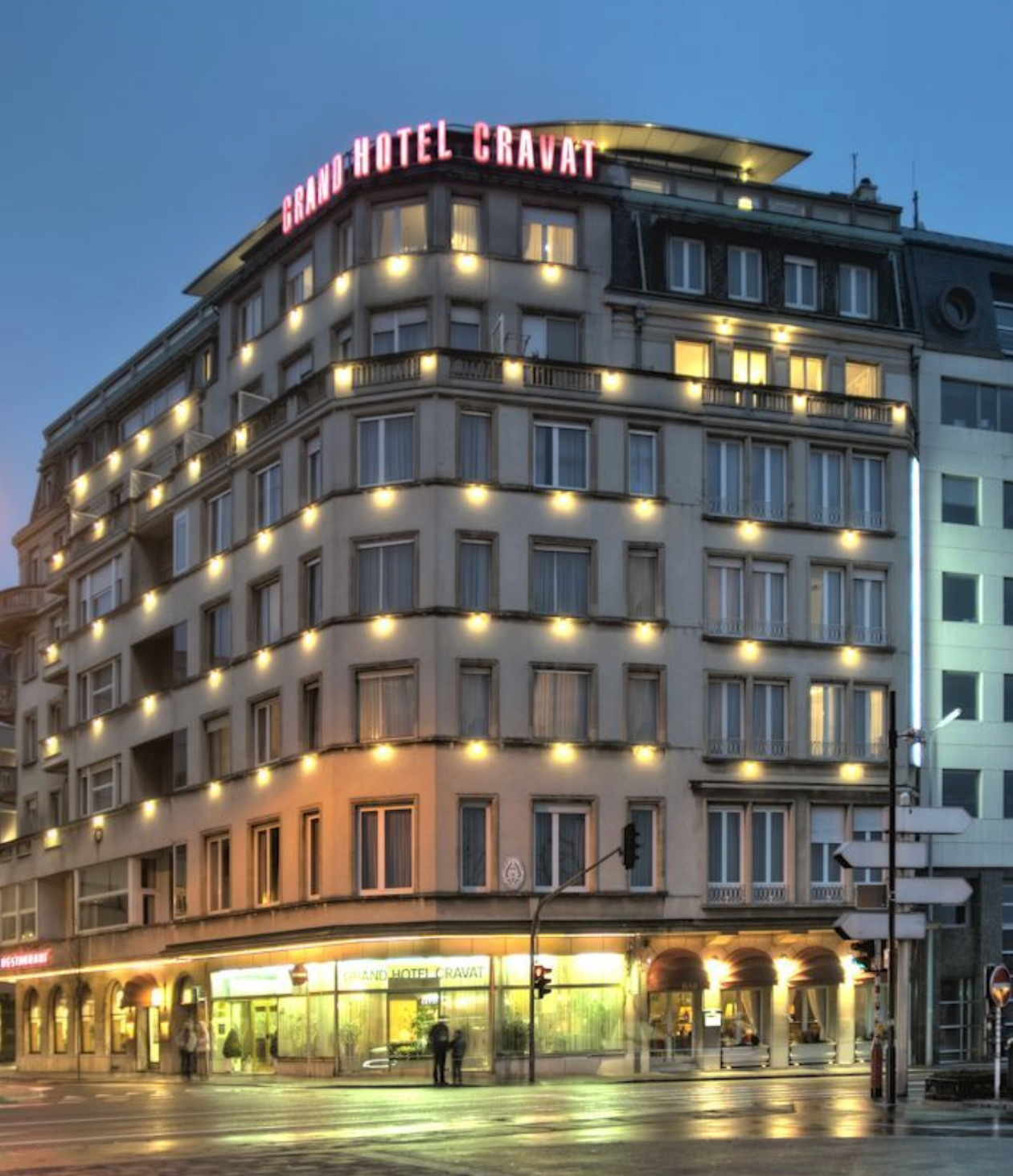 Modern hotel building exterior with illuminated facade and large windows shown at different times of day and angles.